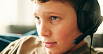 Headphones, home and boy with video game, relax and competition with esports, fun and hobby. Apartment, headset and child on sofa, contest and playing with break, recreation and subscription