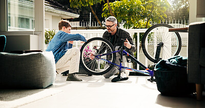 Buy stock photo Father, child and bicycle maintenance for learning, helping and bonding with son at family home. Dad, kid and fix bike together for wheel repair, teaching and cycling hobby at patio with parent