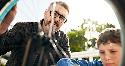 Buy stock photo Dad, boy and help with bike repair, teaching and support with low angle for safety inspection. People, father and child with bicycle maintenance, learning or outdoor in backyard for bonding in France
