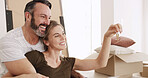 New house, moving and couple with keys, love or happiness for mortgage approval, hug and investment. Man, affection and bonding with woman in lounge, excited and purchase of home with loan or bond