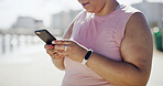 Woman, plus size and hands with phone for fitness app, weight loss program or online course in city. Closeup, female person or research with mobile smartphone for exercise schedule or tips in town