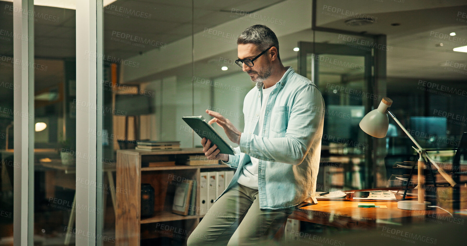 Buy stock photo Night, office and business man on tablet for finance review, online trading and investment news. Mature, scroll and person on digital tech for financial report, budget planning and fintech website