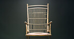 Studio, empty chair and isolation for mental health asylum with mockup space on black background. Seat, vintage and wooden furniture for confinement on backdrop, psychology and antique with cushion