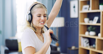 Buy stock photo Singing, hair brush and music with woman in home for karaoke, streaming and soundtrack. Headphones, relax and radio subscription with person in living room of apartment for audio and connection