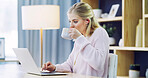 Girl, laptop and drinking with coffee in home for journalism, remote work or online article. Female person, journalist or reading with computer, beverage or caffeine for news or research in house