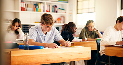 Buy stock photo High school students, boy and writing in lesson for assessment, essay assignment or learning. Teenager, education and people with aptitude test in classroom for scholarship and curriculum knowledge