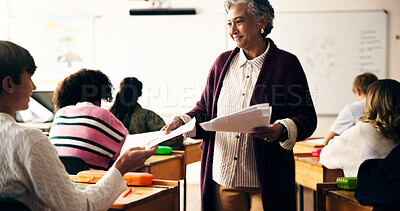 Buy stock photo Teacher, classroom and giving paper for exam with teen pupil, group and results for science assessment. Mature woman, children and smile for test, quiz and learning for education at high school