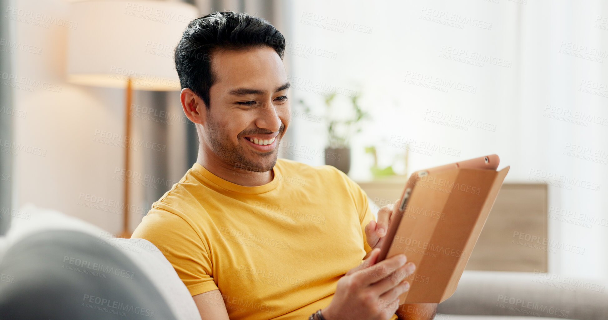 Buy stock photo Tablet, relax and happy man in home for internet, social media post and reading news. Technology, living room and person with app for online forum, communication and check email with notification