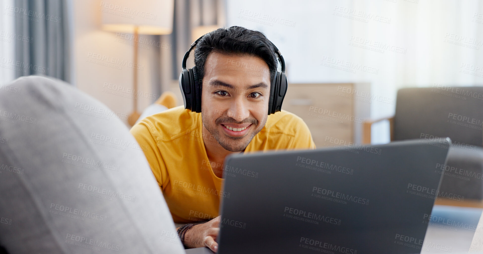 Buy stock photo Man, laptop and headphones on sofa for video, social media and movie streaming or website in home. Relax, internet audio and male person on couch with technology, break and watching film on app