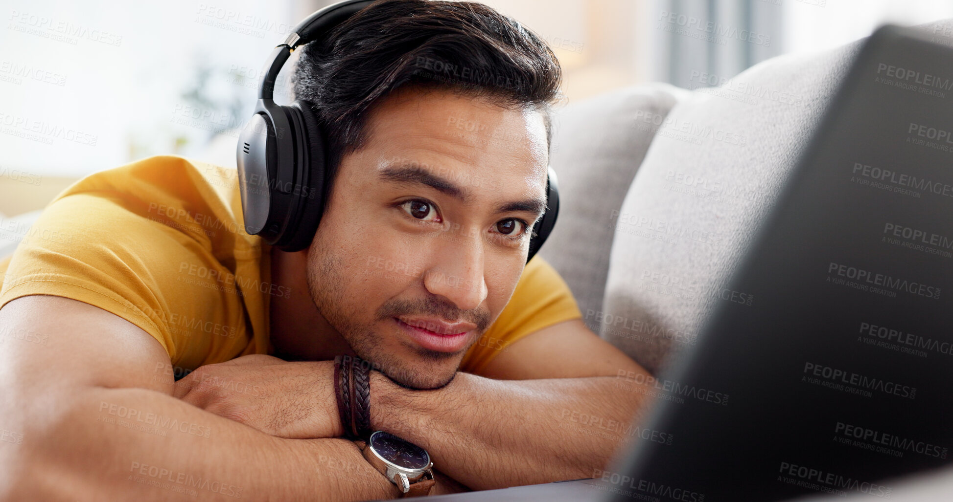 Buy stock photo Relax, laptop and watching with man on sofa for streaming service, headphones and film. Movie subscription, media website and home cinema app with person in living room of apartment for online video