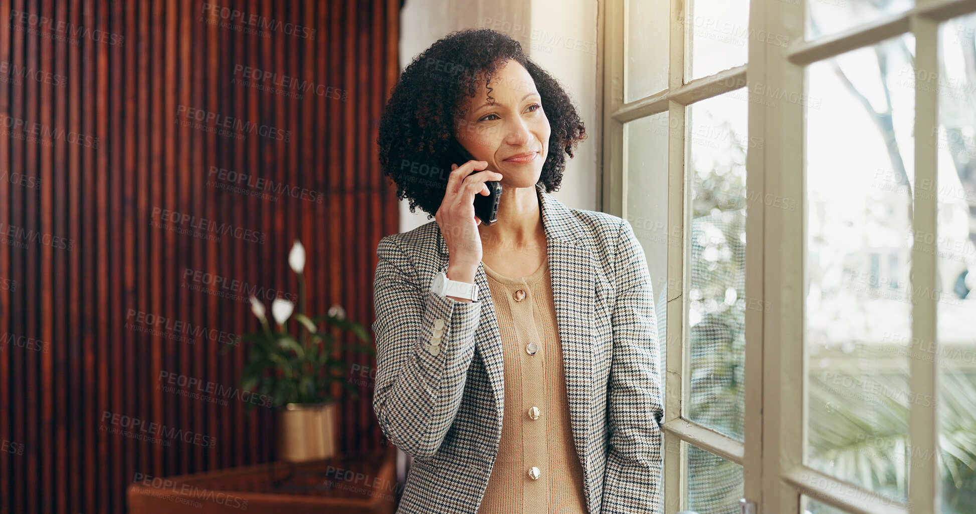 Buy stock photo Woman, phone call and smile by window at office for networking, listen and contact at media company. Person, happy and smartphone with reflection, thinking and decision for deal at creative agency