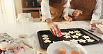 Baking, hands and biscuits on tray in kitchen for teaching, bonding or fun activity together in home. Learning, cooking and people preparing dessert or cookies on counter for development in house.