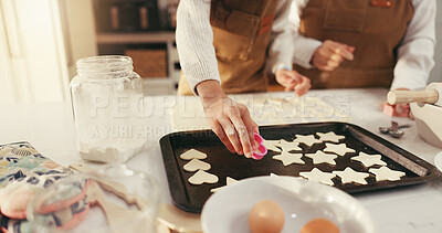 Buy stock photo Baking, hands and biscuits on tray in kitchen for teaching, bonding or fun activity together in home. Learning, cooking and people preparing dessert or cookies on counter for development in house.