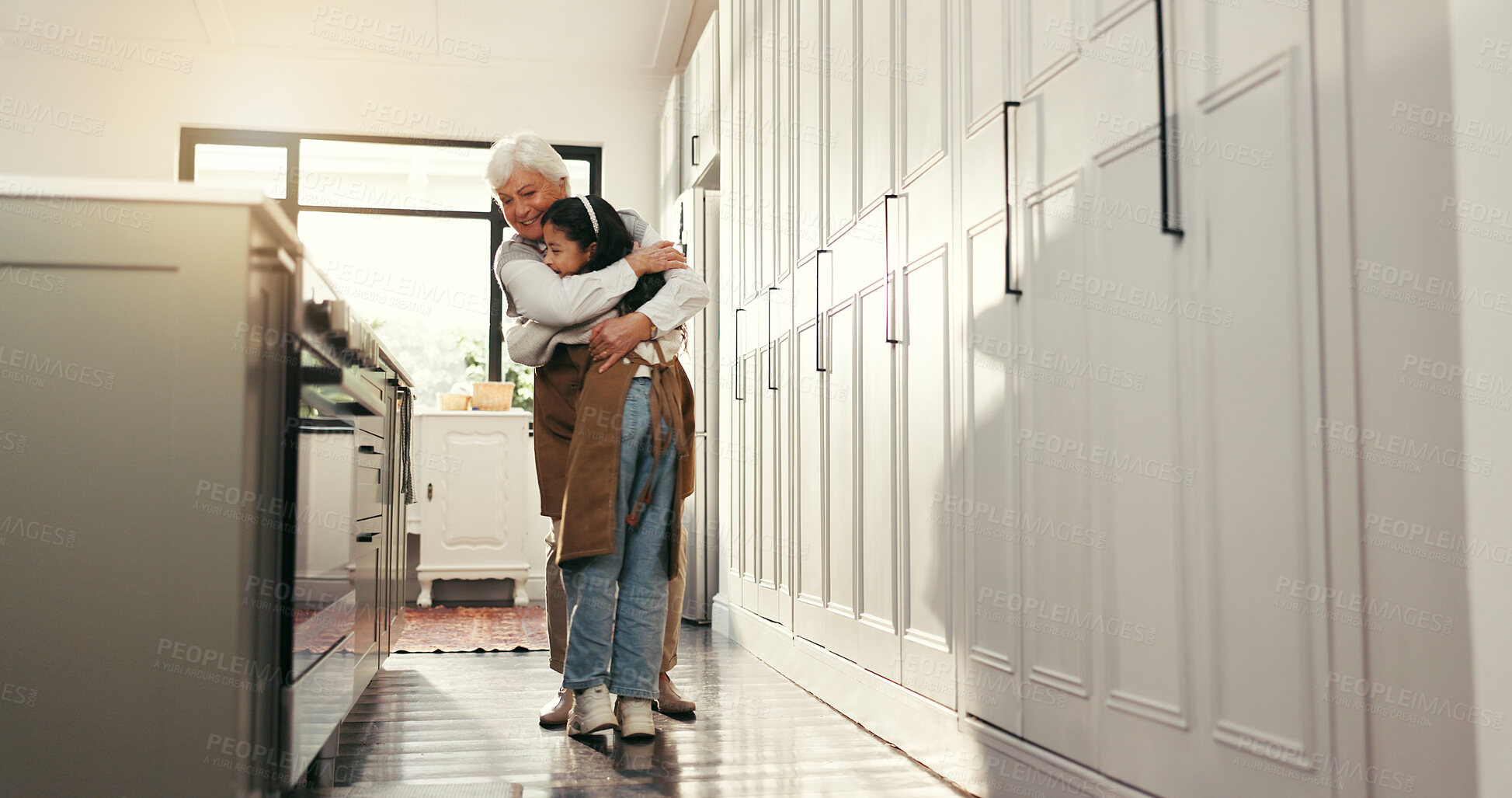 Buy stock photo Hug, reunion and senior woman in kitchen with child, happy family and support for school holiday. Love, relax and people in home with learning, bonding and baking in retirement for education.