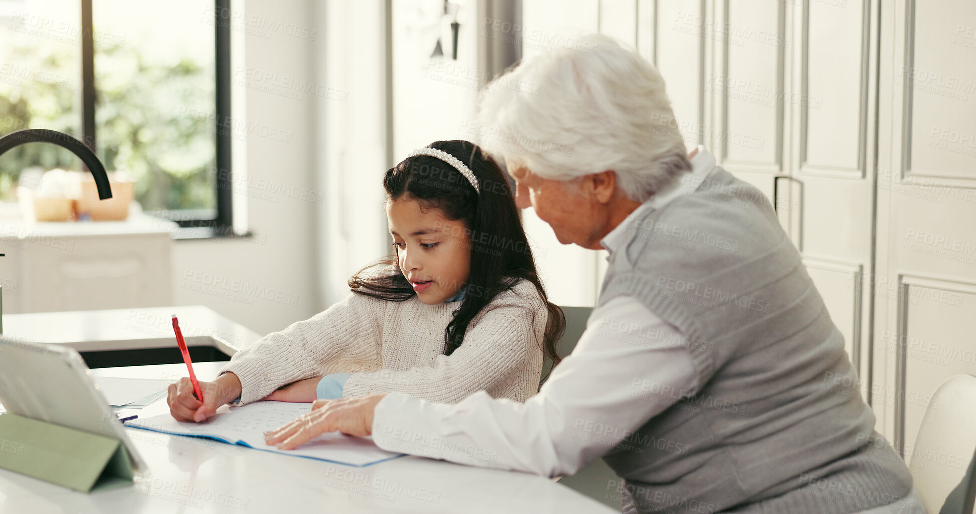 Buy stock photo Girl, grandmother and help with homework, writing and book with support, online course and education in home. People, grandma and child with guide, learning and care for development at family house