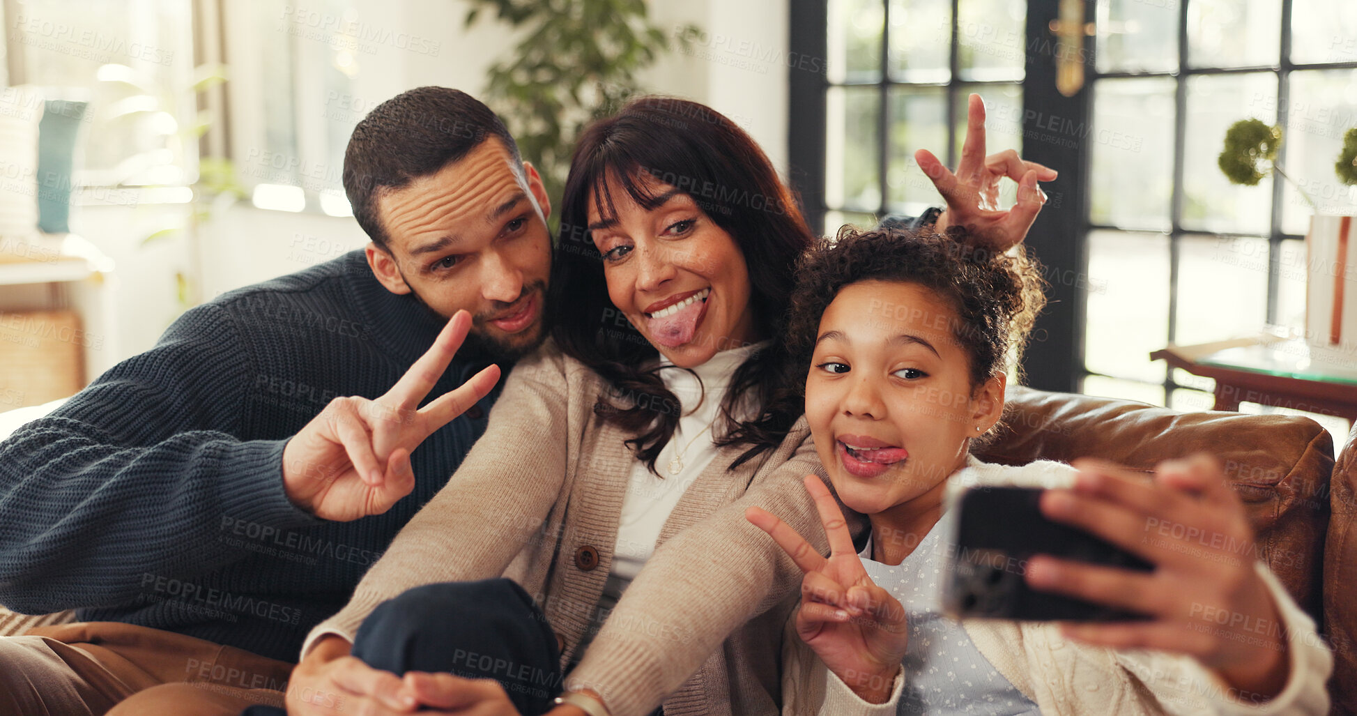 Buy stock photo Parents, girl and selfie on sofa with funny face, smile and peace sign for memory in living room. People, photography and happy for profile picture, v symbol and post on social media at family home