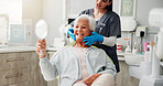 Dentist, senior woman and mirror with results for teeth whitening, dental implant or oral care. Retirement, healthcare and doctor with happy old patient in clinic for dentures or root canal treatment