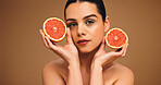 Woman, portrait and grapefruit for natural skincare, organic cosmetics or vitamin C with self care in studio. Female person, dermatology and fruit for healthy skin, beauty and wellness on background