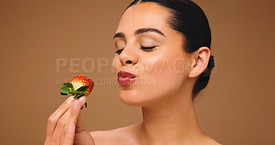 Buy stock photo Girl, beauty and eating strawberry in studio, results and natural makeup with glow on background. Woman, nutrition and organic fruit with dermatology, thinking and diet for benefits with cosmetics