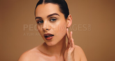 Buy stock photo Cosmetology, makeup portrait and girl in studio with flawless complexion, cosmetics and lipstick. Mockup space, woman and touch face on brown background for foundation coverage and healthy skin glow