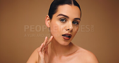 Buy stock photo Cosmetology, makeup portrait and woman in studio with flawless complexion, cosmetics and lipstick. Mockup space, girl and touch face on brown background for foundation coverage and healthy skin glow