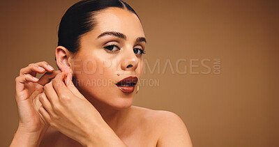 Buy stock photo Woman, beauty and earring with studio portrait, pride and confidence with mockup space on background. Girl, model and face with cosmetics for glow, makeup and jewellery with transformation in Australia