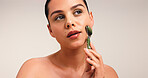 Skincare, cosmetic and woman with facial roller in studio with natural, beauty and glow. Health, mockup space and female person with face tool for dermatology routine for wellness by white background