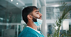 Man, surgeon and sad in lobby with thinking, fatigue and stress with grief for lost patient at hospital. Person, doctor and depression by window with reflection, memory or burnout with job at clinic