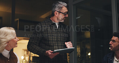 Buy stock photo Man, tablet and discussion with team at night, creative pitch planning and online research for digital marketing. Brand campaign, social media and mature person with tech, group and project deadline