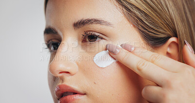Buy stock photo Beauty, skincare and girl with face cream in studio for hydration, skin protection or anti aging. Self care, person and moisturizer application on white background for radiant complexion, SPF or glow