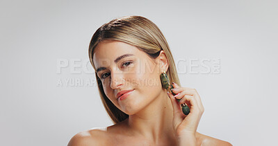 Buy stock photo Face roller, skincare and portrait of woman in studio for dermatology, smooth skin or grooming. Mockup, space and person with beauty tools for facial massage, anti aging or health on white background