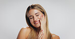 Beauty, girl and happy with skincare in studio for acne treatment results, healthy glow or self care. Mockup space, person and touching face on white background with skin wellness and natural makeup