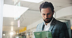 Businessman, reading and planning with tablet on glass board for schedule, agenda or project tasks. Man, employee or planner with technology, ideas or sticky notes for mindmap or brainstorming work