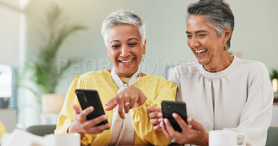 Buy stock photo Coffee, laughing and phone with senior friends in living room of home for humor, comedy or visit. App, funny and meme with old women at table together for bonding, joke or reaction to social media