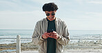 Social media, promenade or man typing with phone, holiday adventure or internet post for travel update. Vacation, mobile app or person on beach with space, writing caption or sunglasses for picture