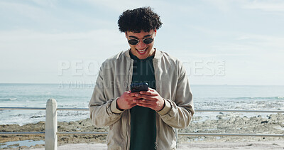 Buy stock photo Sunglasses, promenade or man typing with phone, holiday adventure or internet post for travel update. Vacation, mobile app or person on beach with space, writing caption or social media for sharing