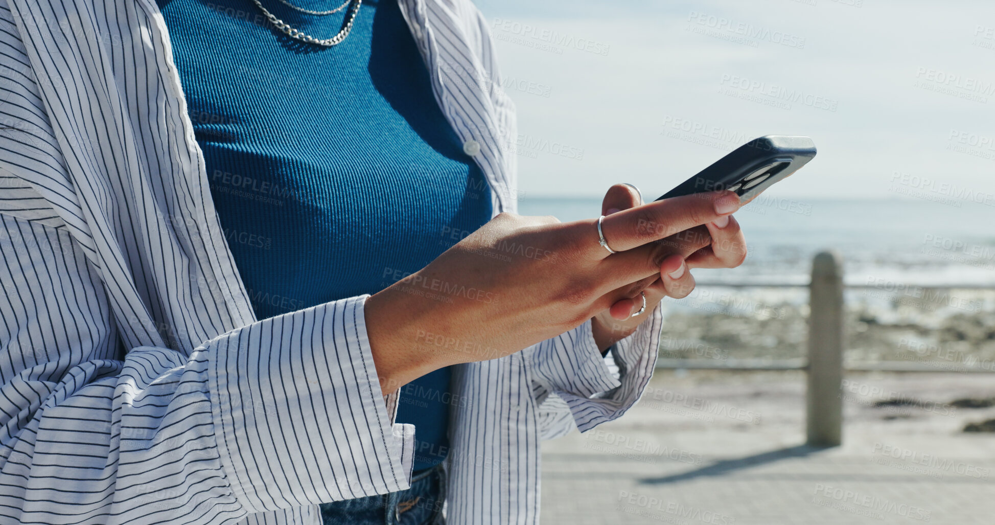 Buy stock photo Hands, woman and phone on promenade for travel, social media and message contact on holiday. Female person, mobile app and texting, online chatting and fresh air for ocean vacation of getaway trip