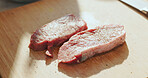 Wood board, dinner or raw organic steak in kitchen, meal preparation or nutrition for protein diet. Salt, pepper or meat on cutting block for flavor balance, gourmet recipe or healthy food for supper