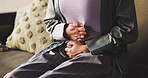 Cramps, hands and woman with stomach pain on sofa from menstrual cycle, PMS and abdomen bloating. Period, discomfort and person with tummy ache in home with gastrointestinal issue and uncomfortable