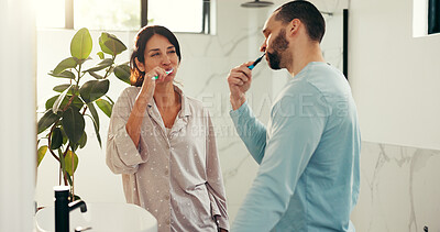 Buy stock photo Happy couple, brushing teeth and bathroom with toothbrush for dental hygiene or morning routine. Man, woman or fresh breath with clean mouth for gum, oral care or health and wellness together in home