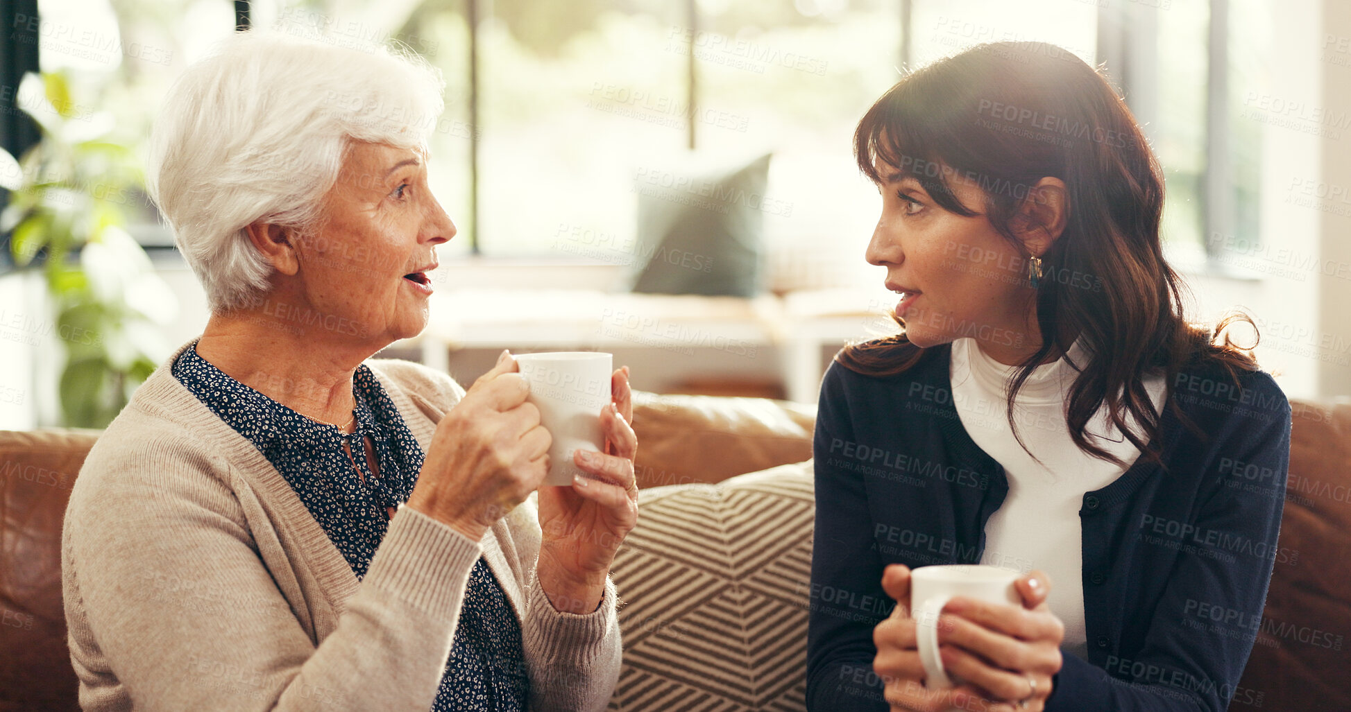 Buy stock photo Senior, mother and daughter with coffee in home for gossip story, bonding or weekend visit on sofa. Family, women or relax in living room with wow conversation, tea and morning reunion for connection