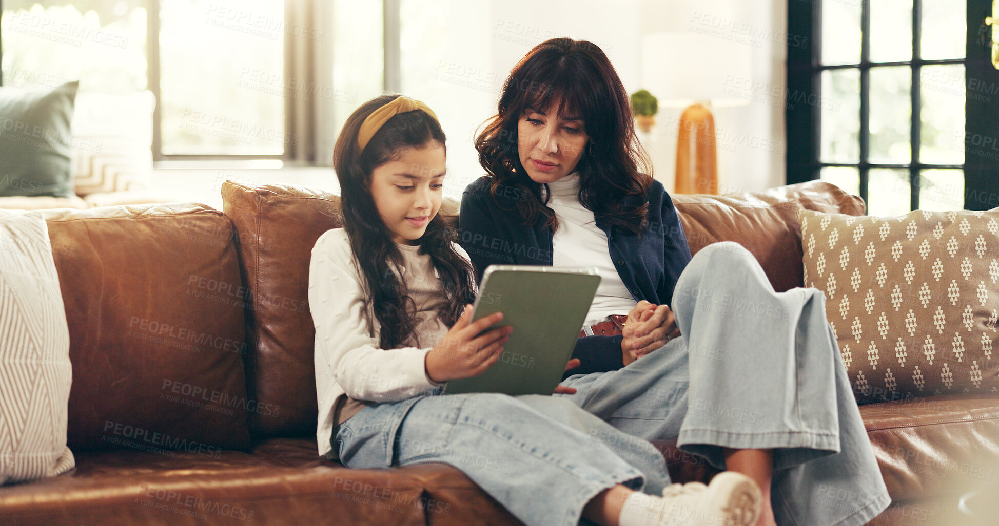 Buy stock photo Home, tablet and mother on sofa, girl and bonding together with education games on internet. Learning, parent and family on couch, mama and daughter with tech, network and digital app for puzzle