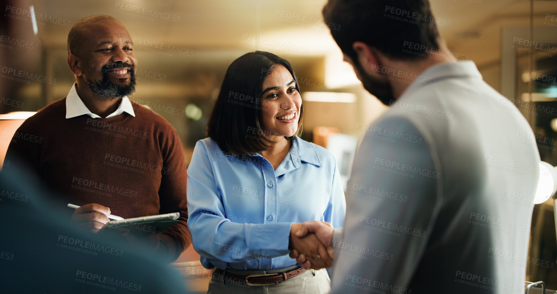 Buy stock photo Shaking hands, meeting and smile with business people in office at night for feedback success. Tablet, handshake and welcome with employee team for work goals, collaboration or partnership strategy