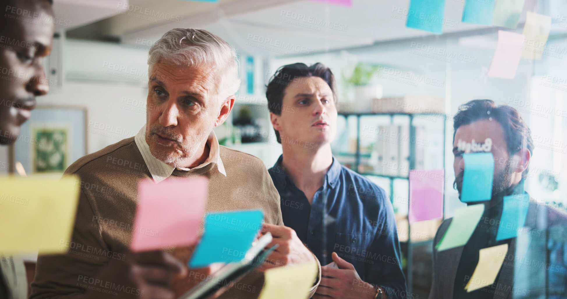 Buy stock photo Man, glass wall and planning with group, talk and brainstorming with tablet at media company. Business people, mature leader and team at startup, sticky note and collaboration at creative agency