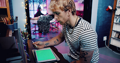 Buy stock photo Man, tattoo artist or tablet with green screen in shop for digital art or creative planning. Male person, tattooist or designer with technology display for precision, styling or retouch in body store