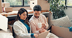 Laptop, boxes and couple in new home for planning mortgage, property or investment deal. Computer, reading and man with woman for real estate research with information by cardboard in house together.