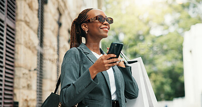 Buy stock photo Shopping bags, smartphone and black woman in city, sunglasses and smile with commute. Outdoor, shades and African person with cellphone, retail and fashion with discount deal, travel and mobile app