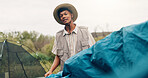 Camping, man and pitch tent in nature for weekend break, holiday adventure or preparation. Countryside, travel and person setting up shelter at campsite for outdoor vacation, assemble or getaway trip