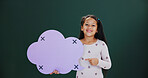 Portrait, pointing and girl in studio, speech bubble and announcement on green background. Happy kid, child development and cloud space with card, promotion and smile with feedback and offer info