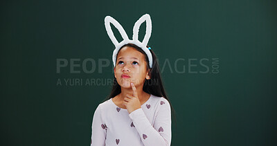 Buy stock photo Bunny ears, Easter and thinking with girl child in studio for holiday ideas or planning. Choice, decision and mockup space with thoughtful kid isolated on green background for selection or vision